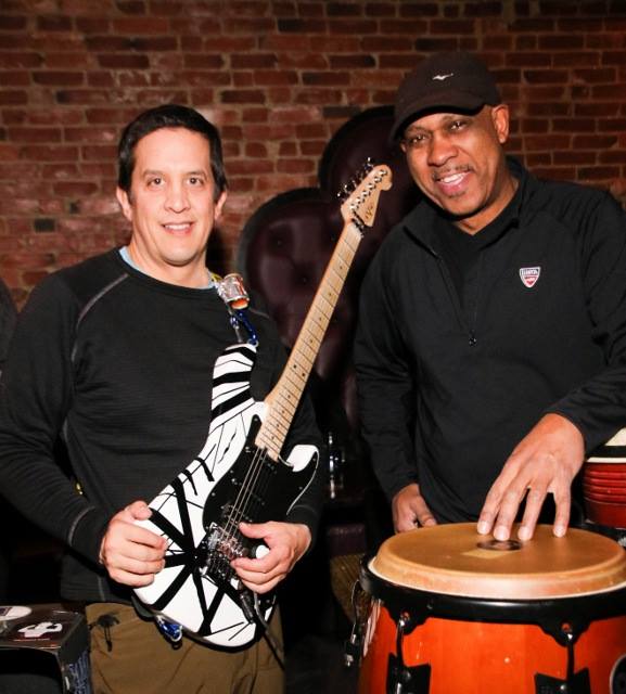 Andre on congas alongside a guitarist at a live show